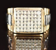 A 9ct gold bi-coloured ring set with diamonds in rectangular setting with ridged decoration to the
