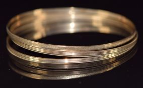 Three 9ct gold bangles with textured decoration, 11.1g