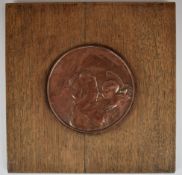 Arts & Crafts copper plaque depicting an angel holding a putti, diameter 16cm, on oak panel, width