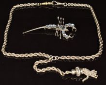 A silver necklace / fob chain with tassel charm and a brooch in the form of a scorpion set with