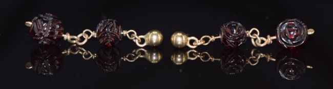 A pair of 9ct gold earrings set with carved cherry amber beads