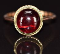 A 9ct gold ring set with a foiled garnet cabochon, 3.1g, size O
