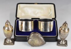 Cased pair of hallmarked silver napkin rings and a pair of hallmarked silver peppers, height 8.