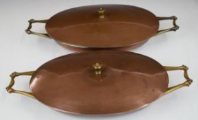 WAS Benson Arts & Crafts pair of twin handled copper and brass covered dishes, length 32cm