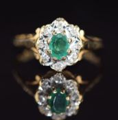 A 9ct gold ring set with an oval cut emerald surrounded by diamonds, 2g, size O