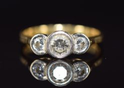 An 18ct gold ring set with three diamonds, the centre diamond approximately 0.35ct, 3.3g, size L