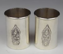 Pair of Thai silver shot measures with embossed decoration of a deity to front, marked to base
