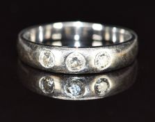 An 18k white gold ring set with three diamonds, the centre diamond approximately 0.08ct, 3g, size I