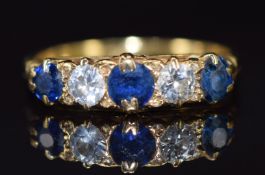 An 18ct gold ring set with three sapphires, the centre sapphire approximately 0.3ct and two