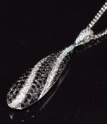An 18k white gold pendant set with black and white diamonds, total diamond weight 0.92ct, with