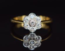 An 18ct gold ring set with seven diamonds in a floral cluster, 3.4g, size N