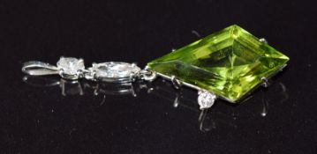 A platinum pendant set with a kite cut peridot of approximately 2ct and marquise, oval and round cut