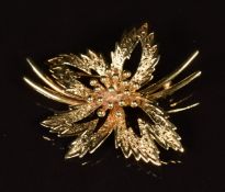 A 9ct gold brooch in the form of a flower with textured surface, 6.2g