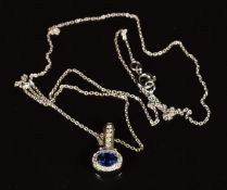 A 14k gold bi-coloured reversible pendant set with an oval cut emerald, oval cut sapphire and
