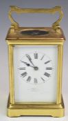 Brass cased carriage clock, with white enamel dial, visible balance wheel to top and striking on a