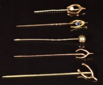 A 9ct gold stick pin in the form of a wishbone set with a sapphire (1.3g), a 9ct gold stick pin in