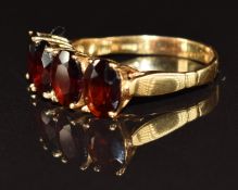 An 18ct gold ring set with four oval cut garnets, 3.6g, size O