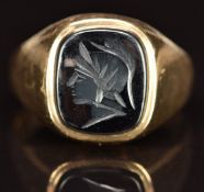A 9ct gold ring set with a carved hematite intaglio, 4.6g, size N