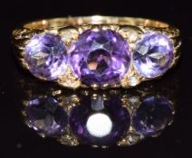 A c1920 18ct gold ring set with three amethysts and four rose cut diamonds, 5.2g, size L