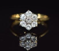 An 18ct gold ring set with seven diamonds in a cluster, each diamond approximately 0.09ct, 3.3g,