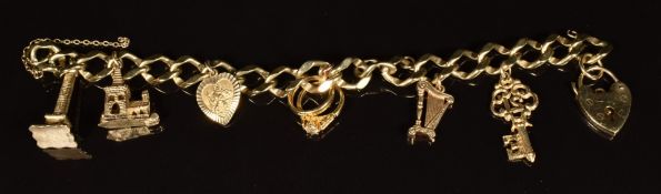 A 9ct gold charm bracelet with six 9ct gold charms including Peel Tower, harp and St Christopher,