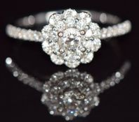 An 18ct white gold ring set with a 0.31ct diamond surrounded by further diamonds, with Tolkowsky
