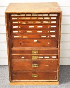 Victorian pine campaign chest of 11 graduated drawers with panelled front door, containing a