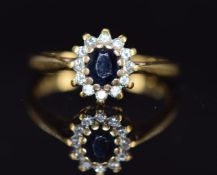 An 18ct gold ring set with a sapphire surrounded by diamonds, 2.8g, size L