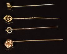 A 9ct gold stick pin in the form of a knot (1g), two stick pins with 15ct gold tops and another