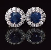 A pair of 14k white gold earrings each set with a round cut sapphire of approximately 0.4ct