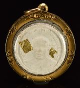 A yellow metal locket or pendant set with a possibly Thai plaster plaque or medallion coin with