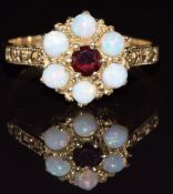 A 9ct gold ring set with a garnet and opals, 2g, size K