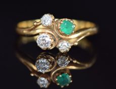 An 18ct gold ring set with an emerald and three old cut diamonds in scrolling/ twist setting, 2.