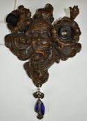 Bronze wall lamp with Art Nouveau style swag and floral decoration beside a lady's face, height