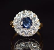 An 18ct gold ring set with a sapphire of approximately 1.25ct and diamonds in a cluster, 6.1g,