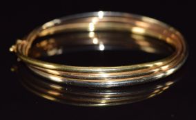 An 18ct gold tri-coloured bangle, 11.9g