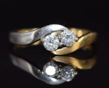 A bi-coloured 18ct gold ring set with two diamonds in a twist setting, total diamond weight 0.