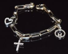 A 14k white gold charm bracelet with three 14k white gold charms/ pendants set with cubic