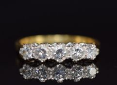 An 18ct gold ring set with five diamonds, the centre diamond approximately 0.18ct, 3.6g, size M