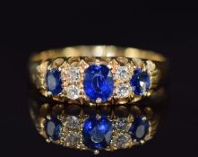 A c1910 18ct gold ring set with three sapphires and rose cut diamonds, 2.9g, size L/M