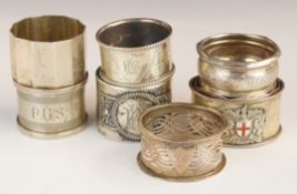 Seven various hallmarked silver napkin rings including one with enamel flag decoration, weight