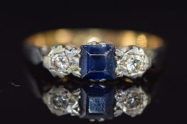 An 18ct gold ring set with a square cut sapphire and diamonds in a platinum setting, 2.6g, size O