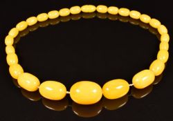 A graduated amber necklace made up of 27 Baltic yellow amber beads, largest bead 17 x 24mm, 50g