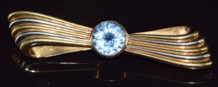 A 14k gold bi-coloured brooch in the form of a stylised bow set with topaz, 12.8g
