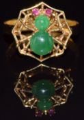 An 18k gold ring in the form of a spider and web set with jadeite cabochons and ruby eyes, 3.1g,