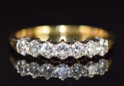 An 18ct gold ring set with seven round brilliant cut diamonds, total diamond weight 0.57ct, with