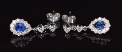 A pair of 18ct gold earrings each set with a pear cut sapphire of approximately 0.45ct surrounded by