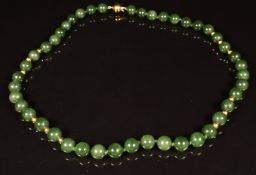 A beaded nephrite jade necklace with 18ct gold clasp and beads