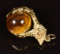 A 9ct gold charm in the form of a claw set with tiger's eye, 5.5g