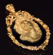 A 9ct gold pendant set with onyx and 9ct gold cameo in relief, and further set with diamonds, 63.7g